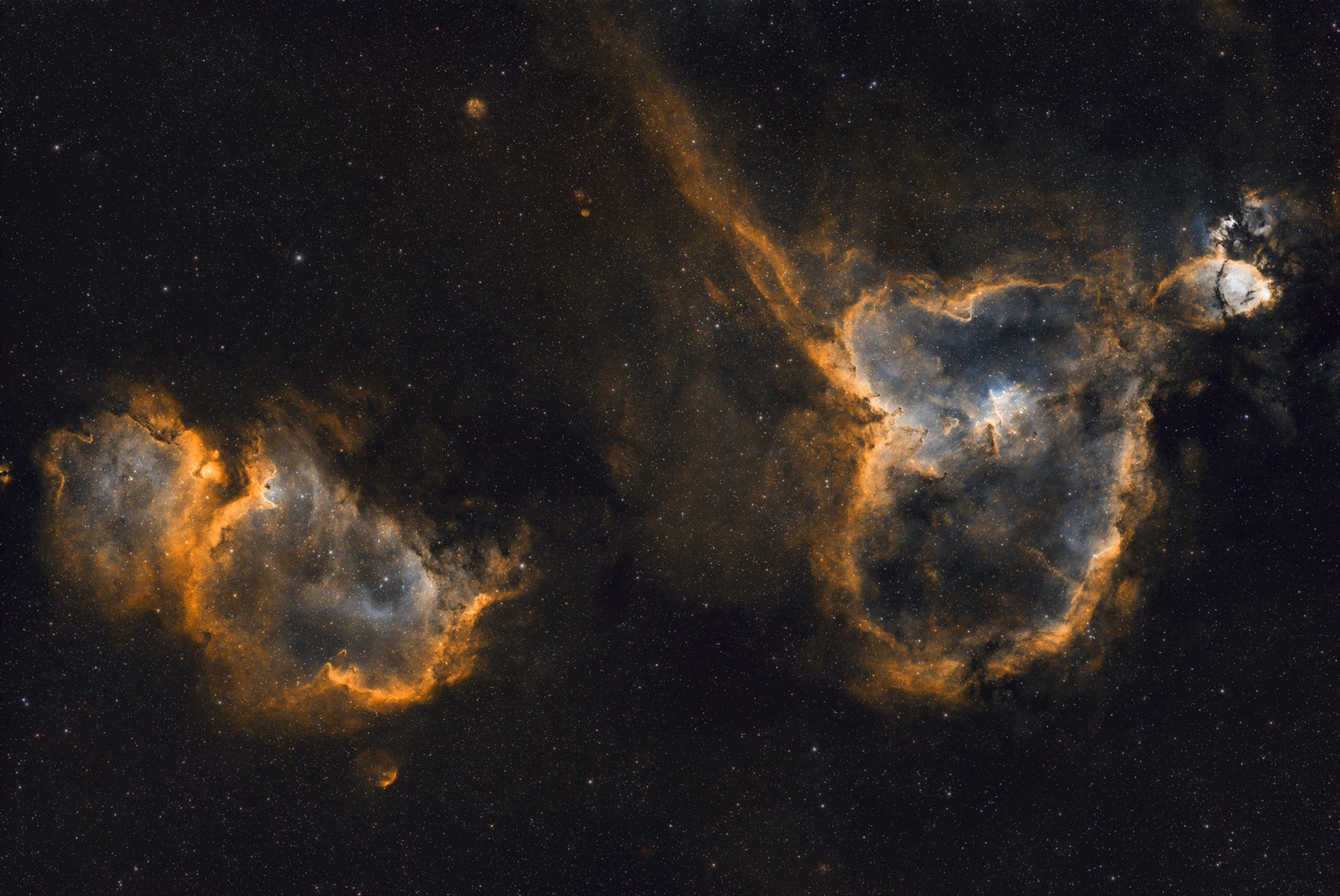 Heart & Soul Nebulae: Two luminous clouds sharing a wide field of stars.
