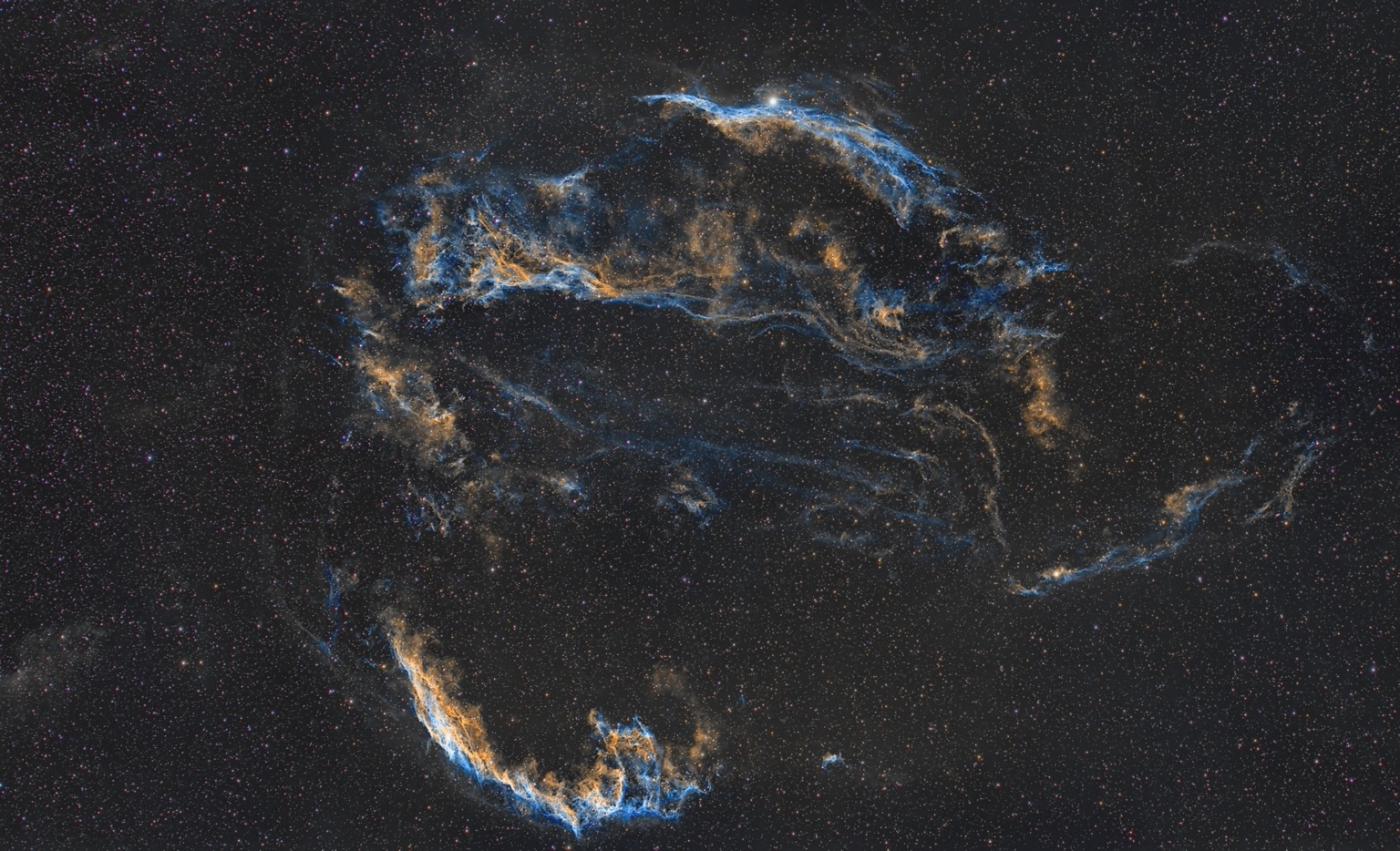 Veil Nebula: Fine blue and gold filaments threaded through the stars.